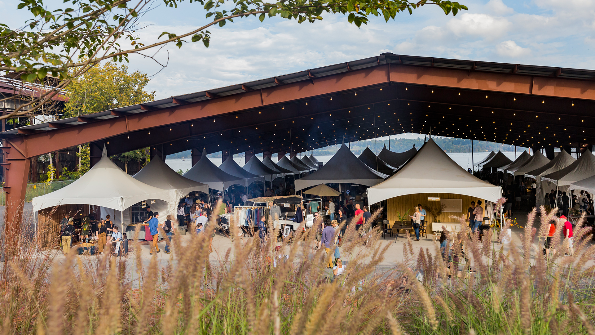 craft market takes place under a shelter situated in the middle of a field.